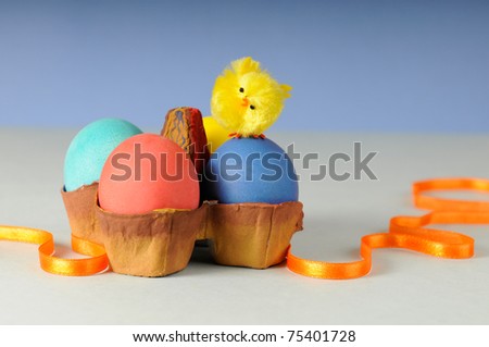colored eggs and toy chicken in easter egg stand