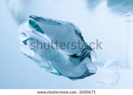 Ice cubes in a glass on a reflective surface