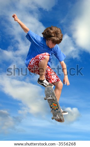 Teenager skater high jump against clear blue
