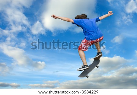 Teenager skater high jump against clear blue