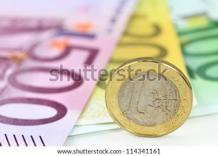One euro coin against euro banknotes. Shallow DOF on euro coin