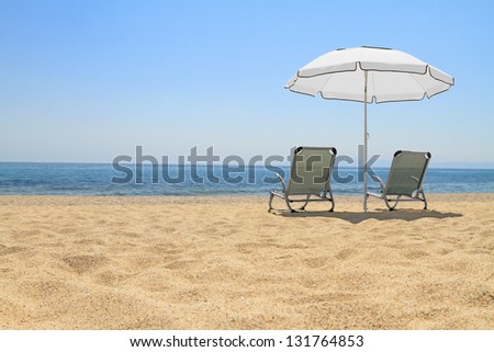 Umbrella and lounge chairs on idyllic beach, in Thassos island - Greece