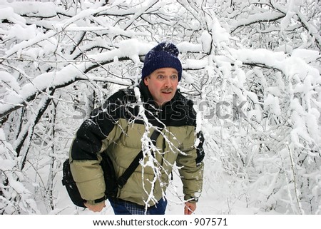 Man Walking through Snow Filled Branches