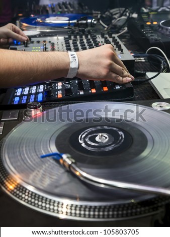 Dj mixes the track in the nightclub at party. Vinyl Player in foreground