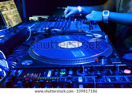 Dj mixes the track in the nightclub at party. Vinyl Player in foreground