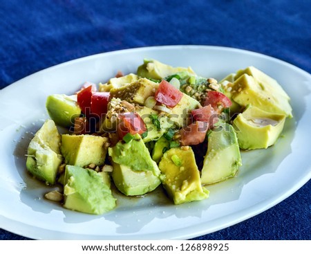Healthy avocado salad with lettuce, tomatoes and nuts