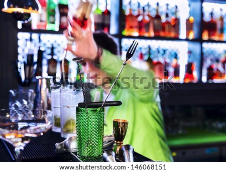 Bar inventory at nightclub. Barman professional making cocktail drinks in background soft focus