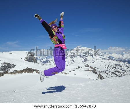 Happy woman jumping on the background of snowy mountains