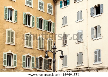 View of the walls old European buildings with open and closed windows. Corner of the house inside the courtyard