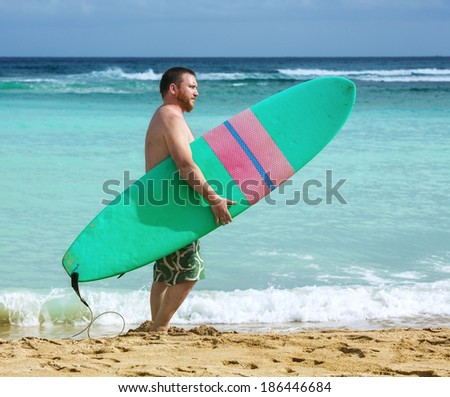 Man holding surf board standing near the ocean