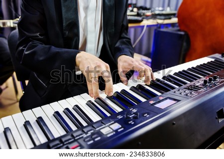 Hands pianist playing on digital piano in a jazz band closeup