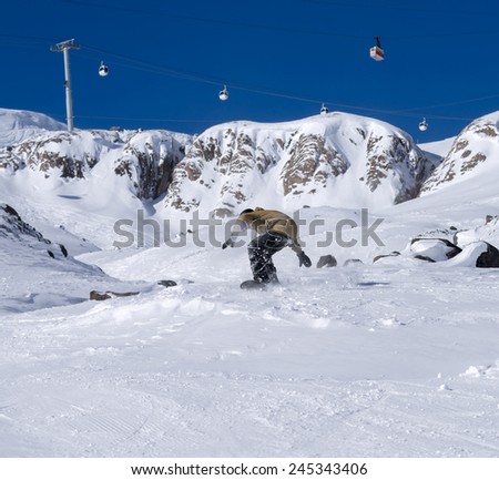 Freerider snowboarder moving down in snow powder on the winter resort