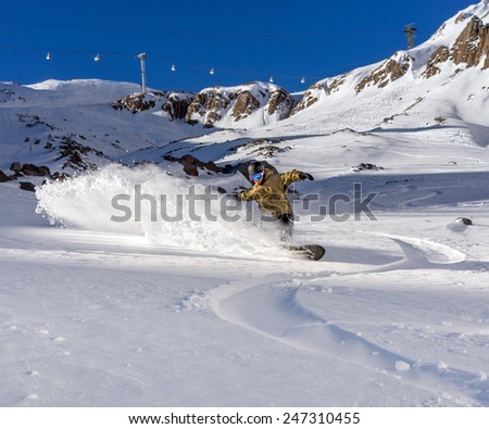 Freerider snowboarder moving down in snow powder on the winter resort
