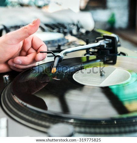 Dj mixes track on vinyl player in club at party