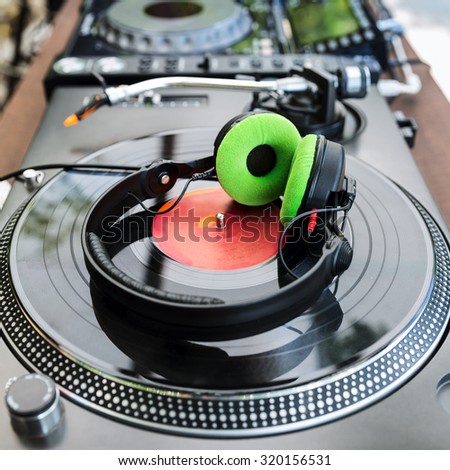 Dj mixer and vinyl player with headphones at club