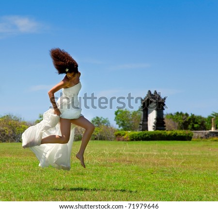 Bride jumped up on a sunny day on the green grass
