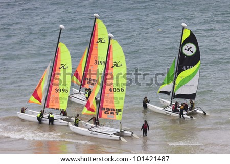 SAINT-MALO, FRANCE - JULY 6: Group of teenagers learning catamaran sailing on the coast of Saint-Malo, France on July 6, 2011. Their Hobie Cat 15 catamarans are 15 feet long and have a great buoyancy.