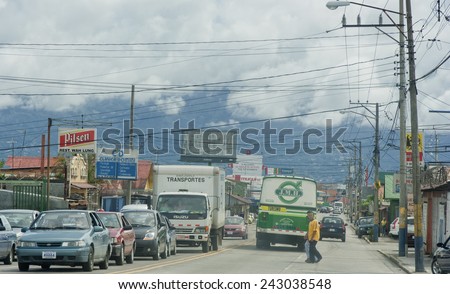 SAN JOSE, COSTA RICA - AUGUST 31, 2008: Traffic jam and crossing people on main street in San Jose, Costa Rica. San Jose is a modern city with bustling commerce and tourism industry.