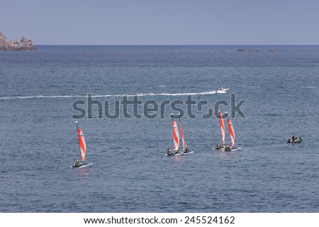 SAINT-MALO, FRANCE - JULY 6, 2011: Group of teenagers learning catamaran sailing on the coast of Saint-Malo. The hull length of their Topaz 12 catamarans is 3.65m.