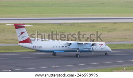 DUESSELDORF, GERMANY - SEPTEMBER 25, 2011: Turboprop airliner Bombardier Dash 8Q-400 of Austrian Arrows landing. This aircraft has a cruise speed of 667km/h and transports about 78 passengers.