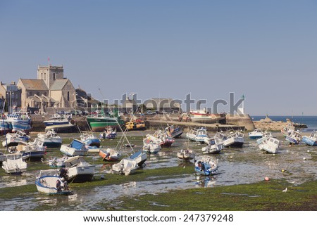 BARFLEUR, FRANCE - JULY 3, 2011: Fishing and recreational boats at low tide in the harbor of Barfleur. Barfleur is a picturesque fishing village in Basse Normandy.