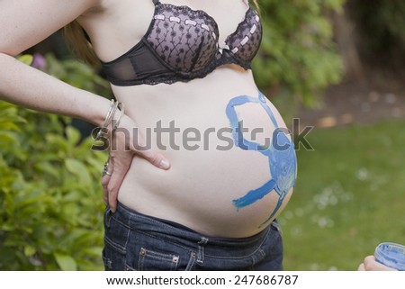 Woman\'s pregnant belly with blue painting
