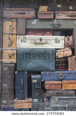 SAINT-MALO, FRANCE - JULY 6, 2011: Ancient suitcases in window display in Saint-Malo, France. On the glass is text with a lot of travel destinations. The town is a main tourist attraction.