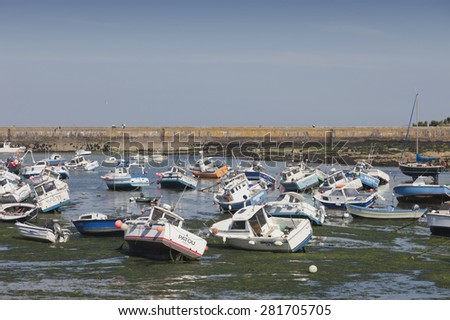 BARFLEUR, FRANCE - JULY 3, 2011: Fishing and recreational boats at low tide in the harbor of Barfleur, France. Barfleur is a picturesque fishing village on the peninsula Cotentin in Basse Normandy.