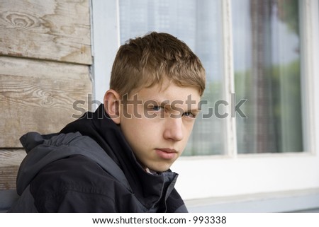 teenager staring into space - in front of a window