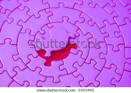 pink jigsaw with the missing piece laying above the space - pieces fitting together in form of a spiral