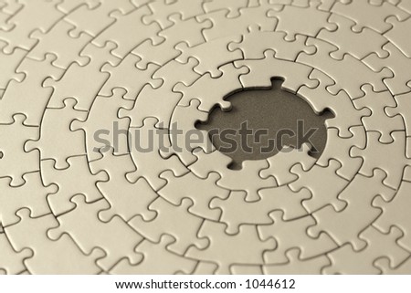 jigsaw in sepia with missing pieces in the center - shallow DOF, focus is on the big hole