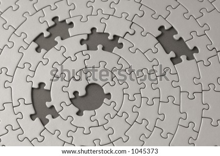 grey jigsaw with five missing pieces - focus is on the center