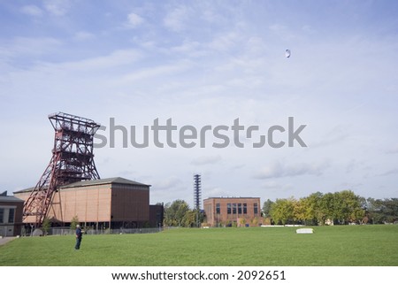 man with a power kite - action in an old industrial area with a shaft tower