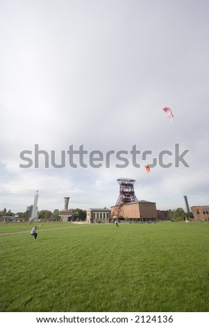 men with power kites - action in an old industrial area with a shaft tower