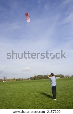 man flying a power kite - action in an old industrial area with a shaft tower