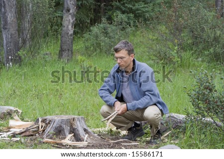 mature man crouching in the woods- jasper national park, canadian rockies