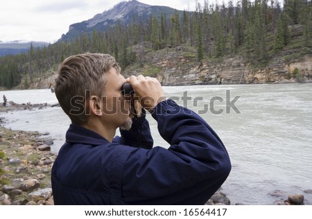 park ranger looking through binoculars