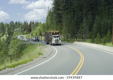Logging truck and cars moving on highway 18 in Canada