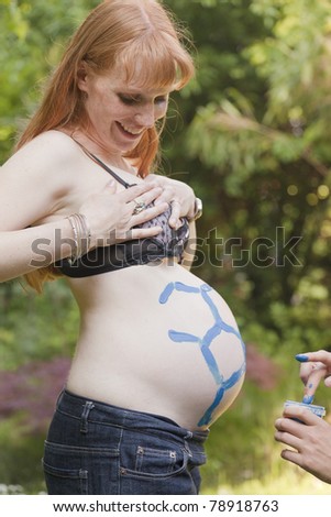 Finger painting on a woman\'s pregnant belly - Germany, Europe
