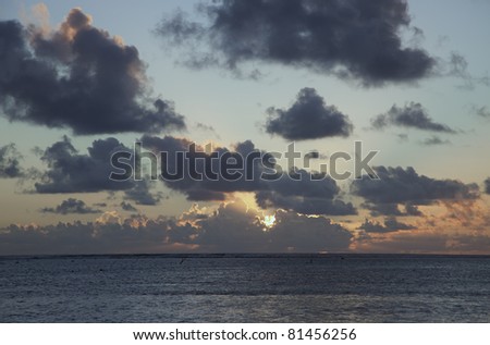 Sun shining through dark Clouds at Sunset over South Pacific Ocean - Rarotonga, Cook Islands, Polynesia