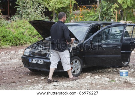 OLYMPOS, TURKEY - OCTOBER 14: Man cleans his car after flood disaster on October 14, 2009 in Olympos, Turkey. The floods destroy roads and houses and swept away about 50 cars.