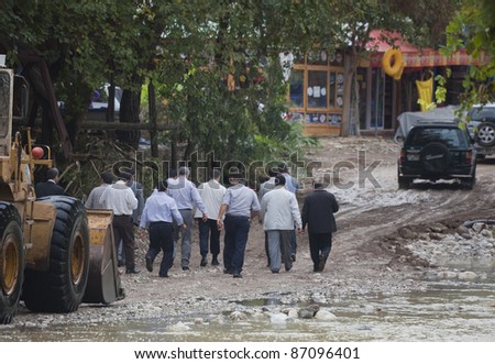 OLYMPOS, TURKEY - OCTOBER 14:  Politicians and civil servants leave the shovel of earth mover used as a ferry for crossing a flooded road after flood disaster on October 14, 2009 in Olympos, Turkey.