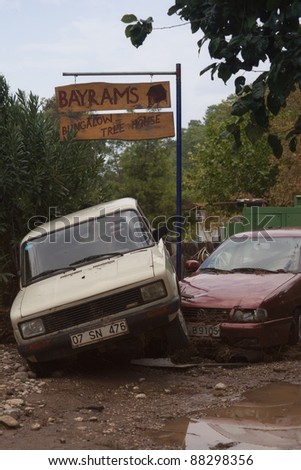 OLYMPOS, TURKEY - OCTOBER 14: Two crashed cars in front of tree houses after flood disaster on October 14, 2009 in Olympos, Turkey, Asia. The floods destroy roads and swept away about 50 cars.