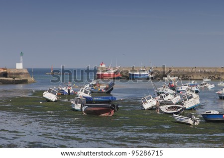 BARFLEUR, FRANCE - JULY 3: Fishing and recreational boats at low tide in the harbor of Barfleur, France on July 3, 2011. Barfleur is a picturesque fishing village in Basse Normandy.