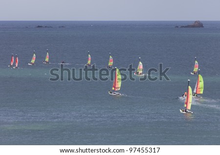 SAINT-MALO, FRANCE - JULY 6: Group of teenagers learning catamaran sailing on the coast of Saint-Malo, France on July 6, 2011. Their Hobie Cat Teddy catamarans are 13 ft long and have a great buoyancy