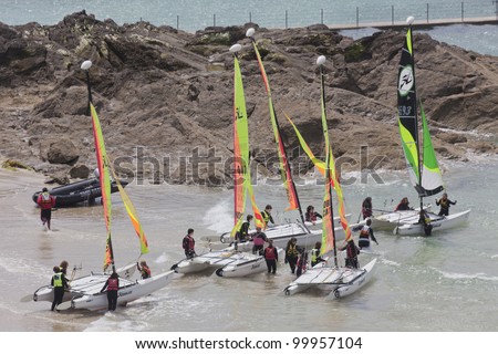 SAINT-MALO, FRANCE - JULY 6: Group of teenagers learning catamaran sailing on the coast of Saint-Malo, France on July 6, 2011. Their Hobie Cat 15 catamarans are 15 feet long and have a great buoyancy.