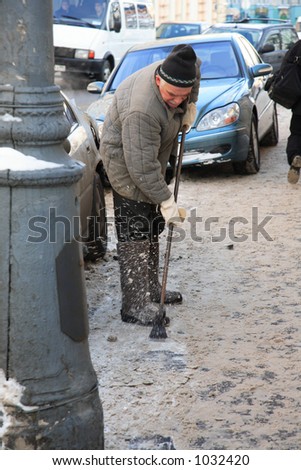 Old man working to remove freeze on the street of Moscow during winter