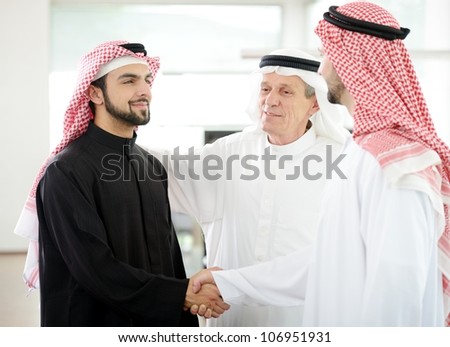Successful Arabic business people shaking hands over a deal