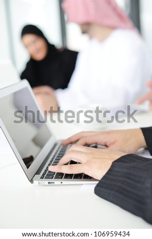 Arabic buisnessman is typing and writing on the laptop