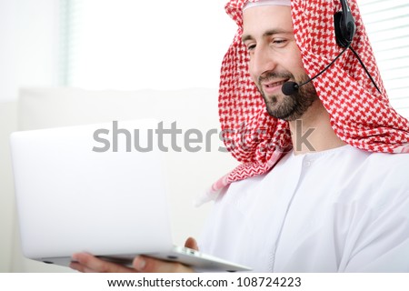 Portrait of a smart arabic business man using laptop and headset. Call center. Customer support. Helpdesk.